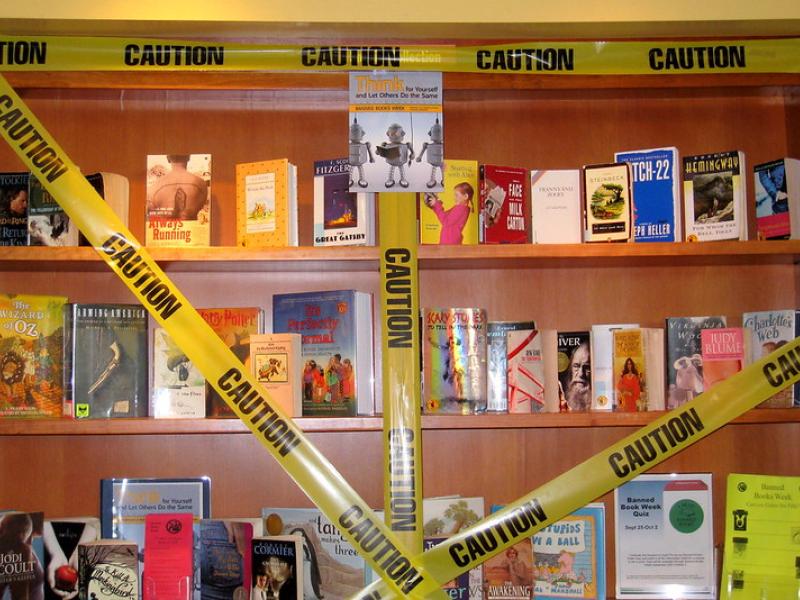 Books on a shelf with caution tape