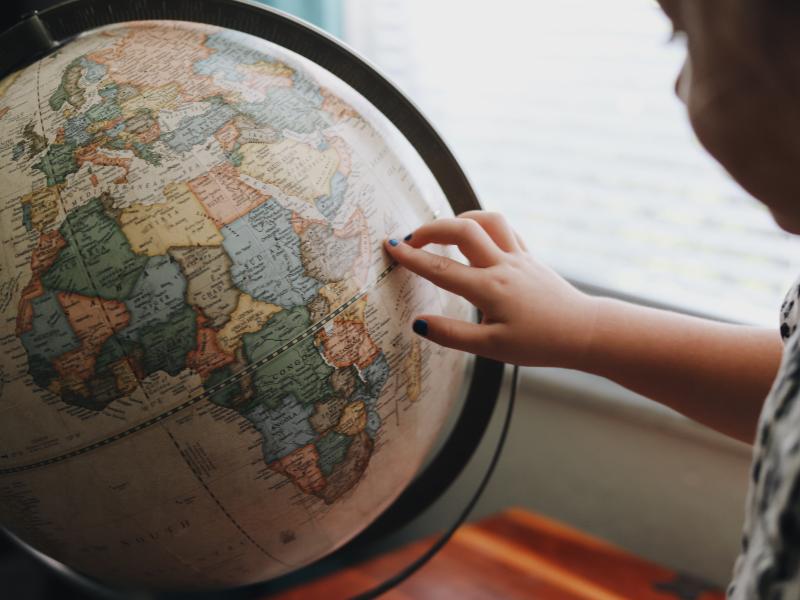 Child's hand on a globe